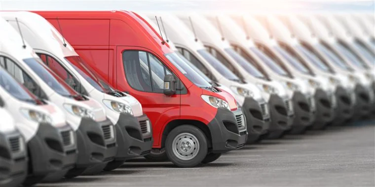 Red delivery van among white vans.